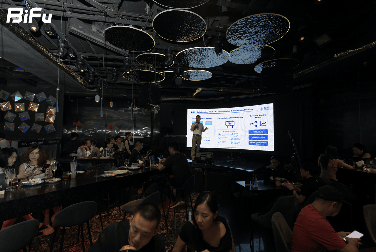 The image shows a scene from BiFu's Token2049 RWA theme dinner and reception. A person is standing on a stage, presenting in front of a large screen displaying diagrams and text. The audience is seated at tables around the stage, some eating and others listening. The venue has a dark ceiling with hanging decorative lights, and the BiFu logo is visible in the top left corner. This corresponds to the context describing the event where 4 speakers discussed RWA from different angles.